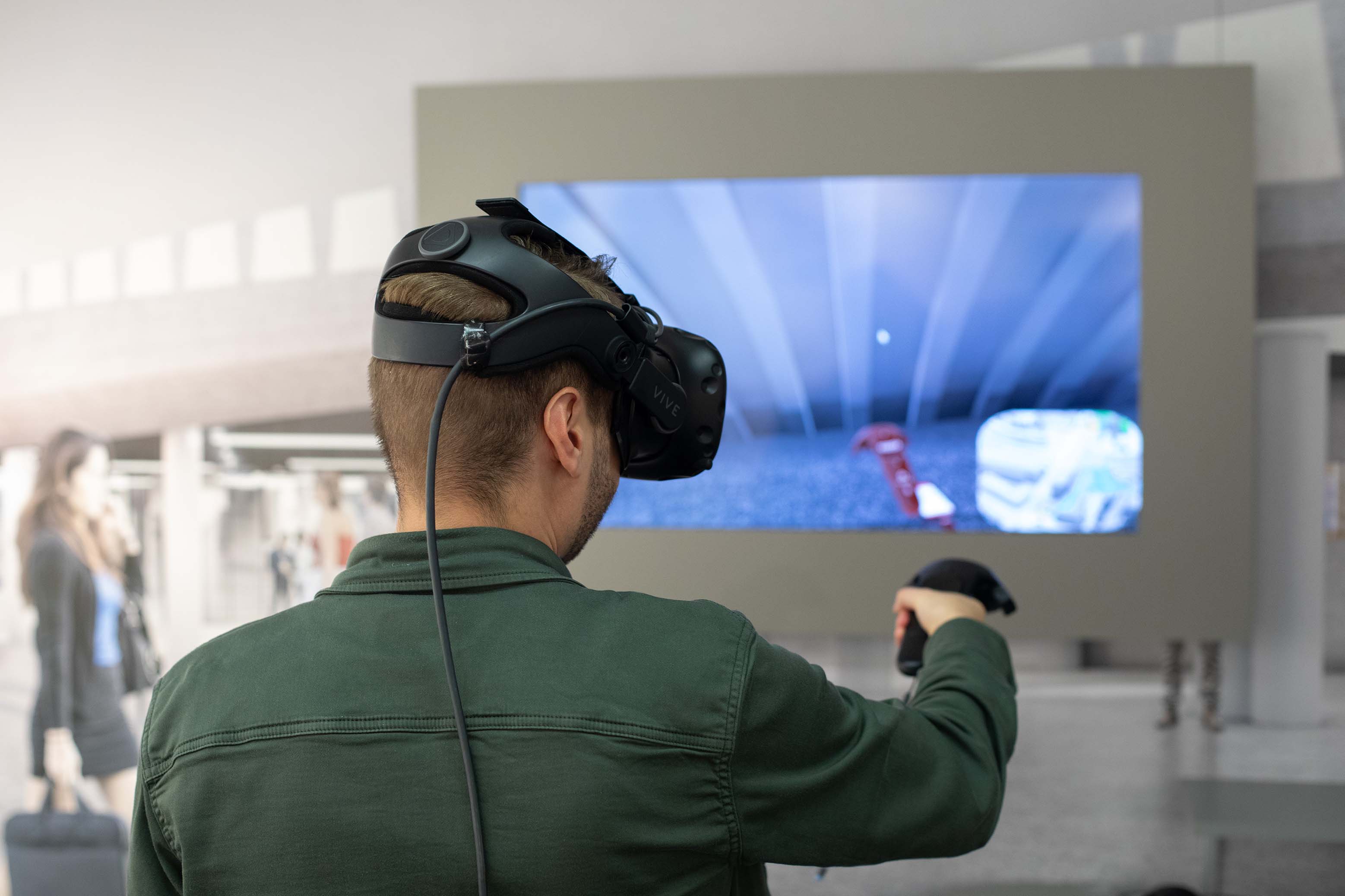 Ein Mann trägt eine VR Brille und läuft den ZBB Bahnhof virtuell durch