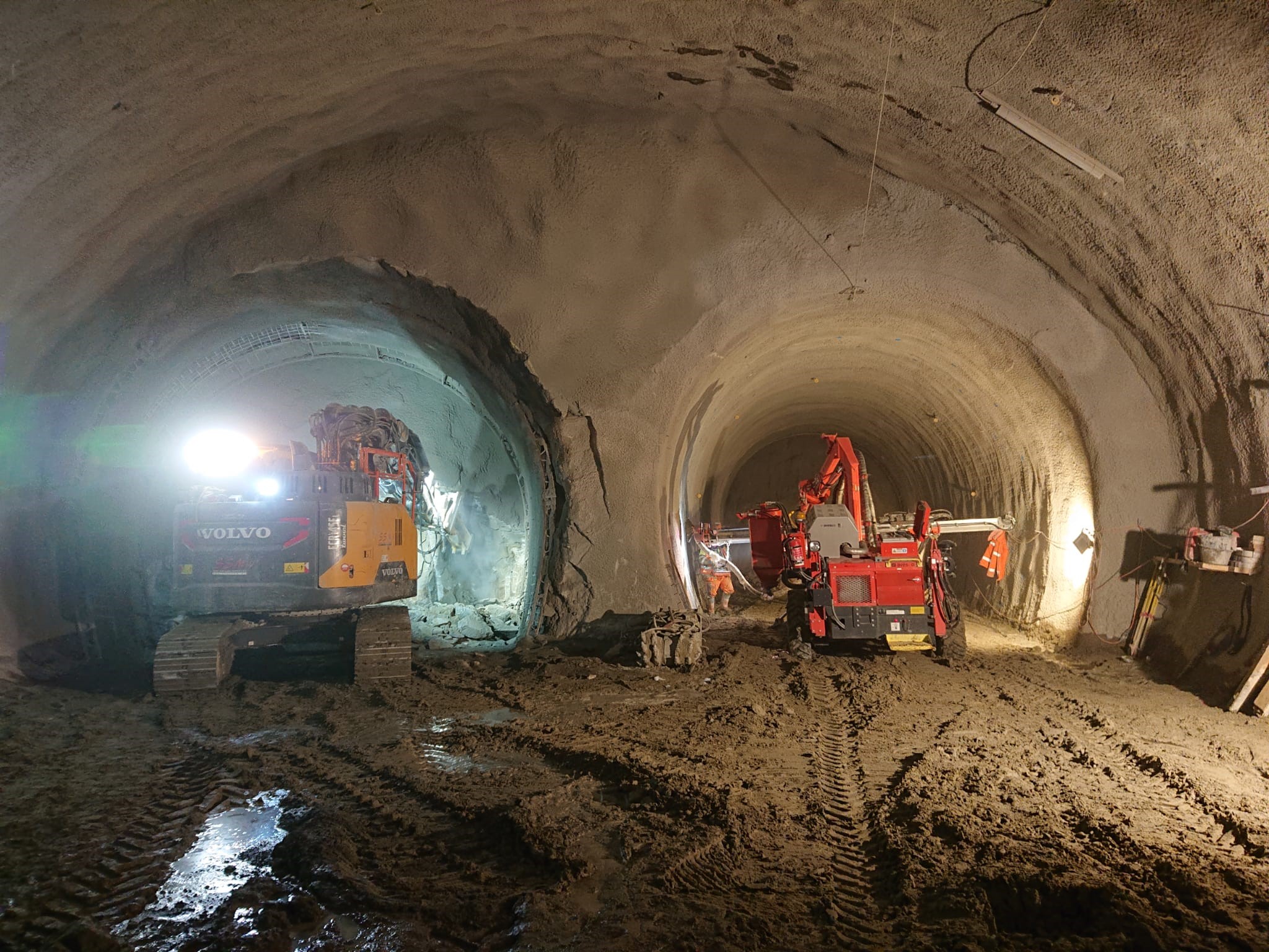 Zwei Baumaschinen bohren Tunnelöffnungen während Tunnelarbeiten