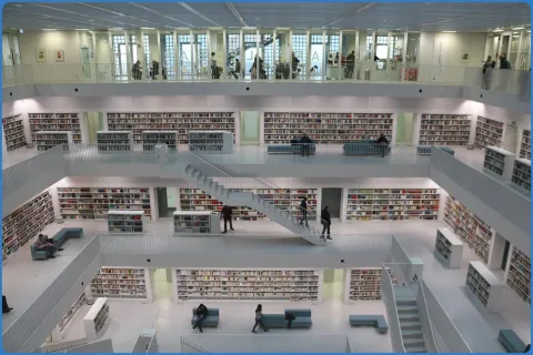 Innenansicht einer modernen Bibliothek mit Regalen und Treppen.