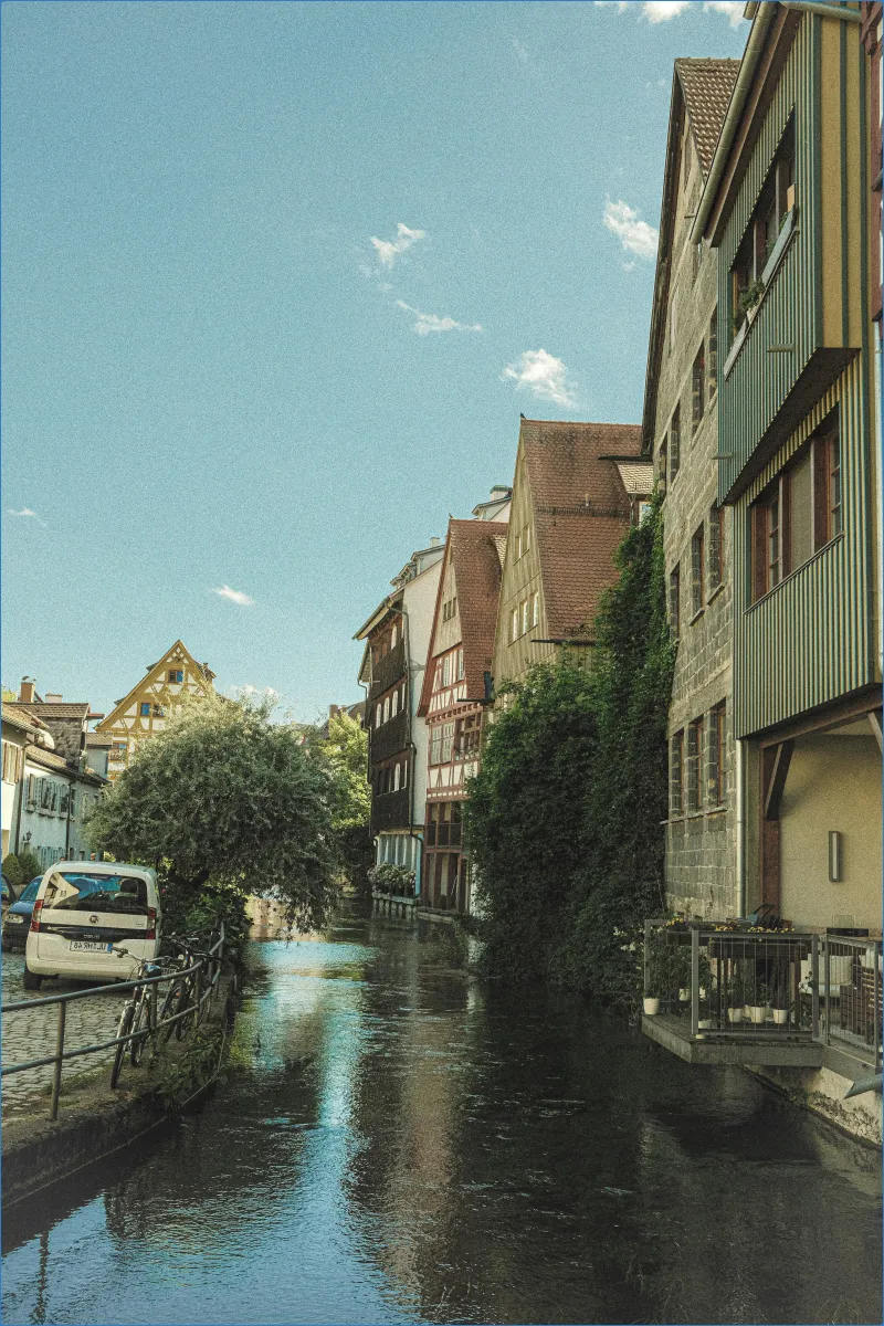 Fluss mit Fachwerkhäusern und blauem Himmel