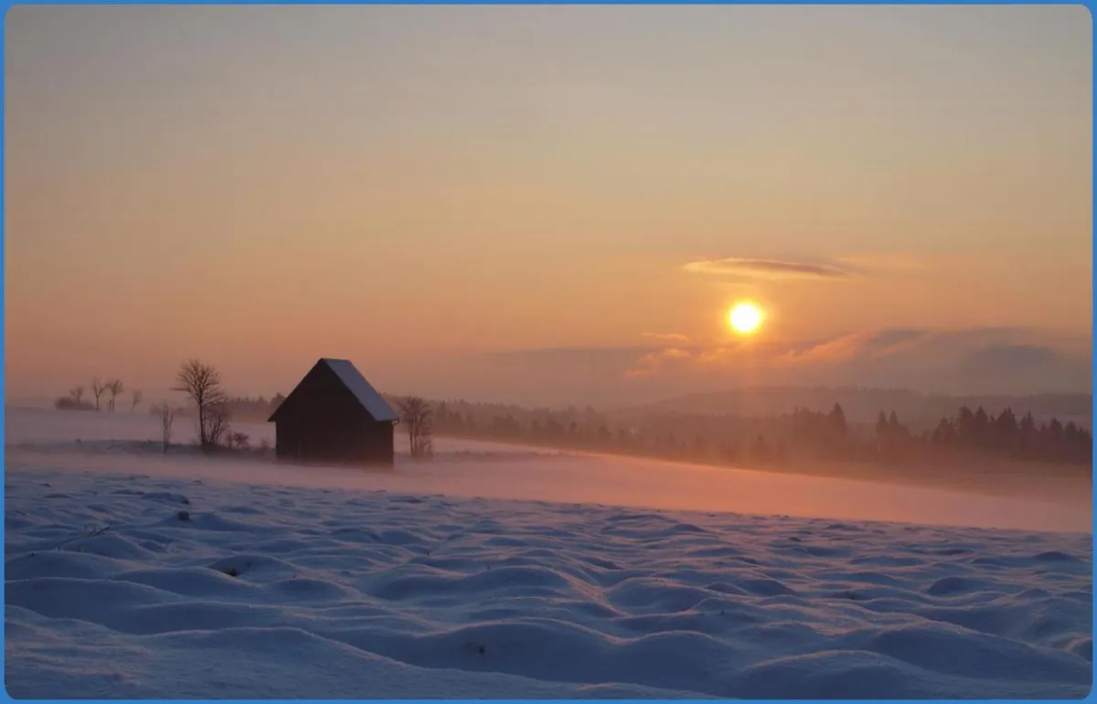 Verschneite Landschaft bei Sonnenuntergang