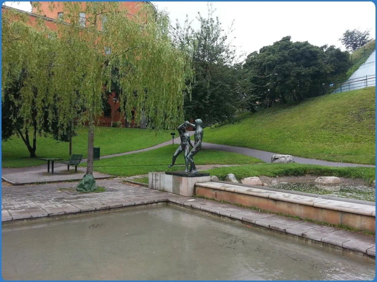 Skulptur in einem Park mit Teich und Bäumen