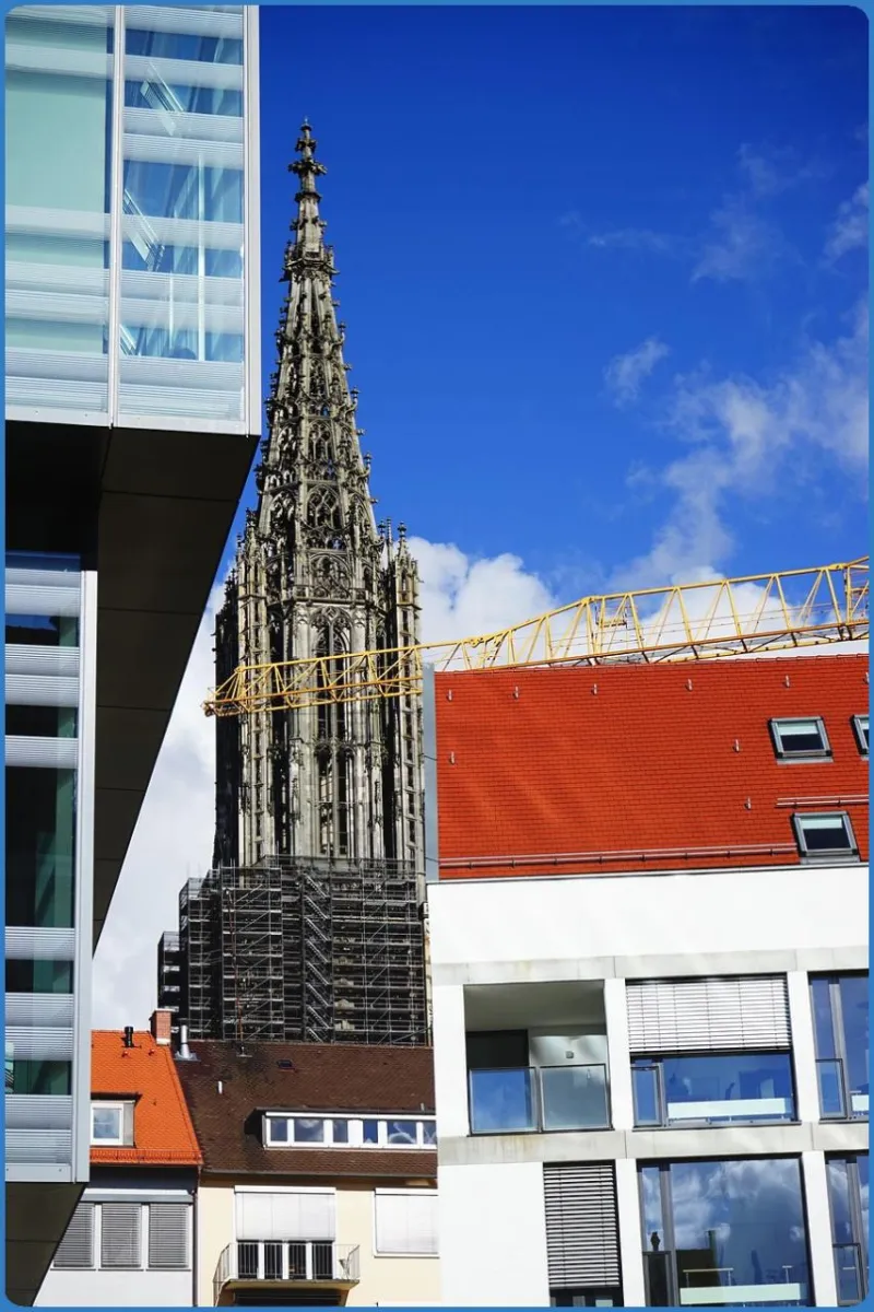 Kirchturm hinter modernen Gebäuden
