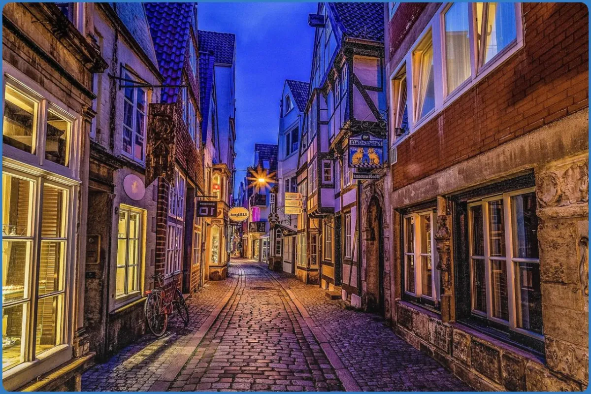 Pflastersteinstraße mit Fachwerkhäusern bei Nacht
