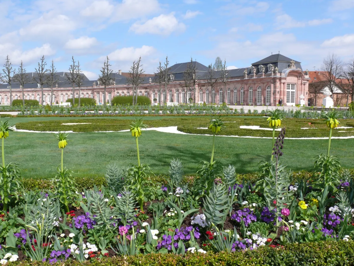Schloss mit Garten und Blumen im Vordergrund