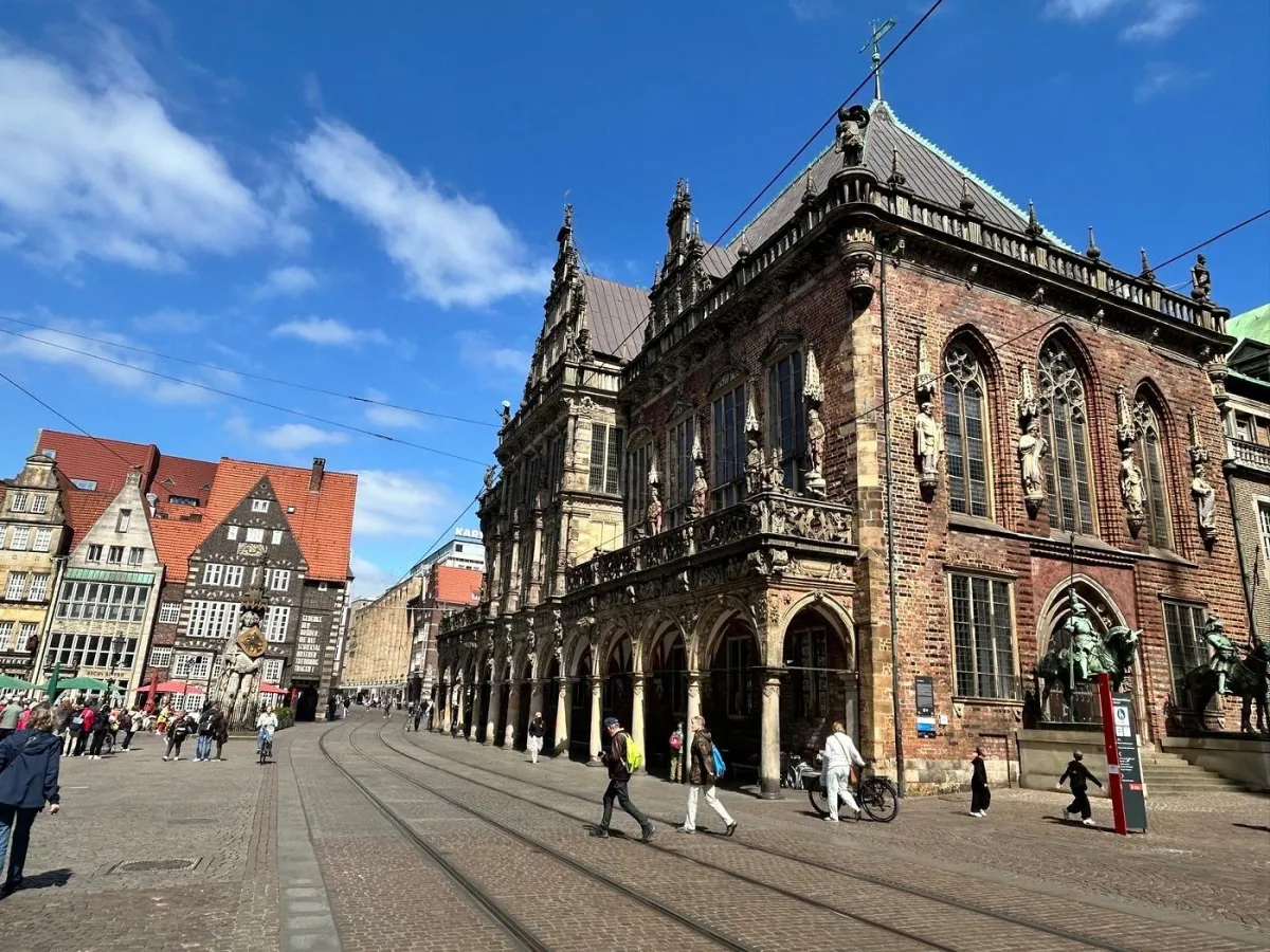 Historisches Gebäude und Menschen auf einem Platz.