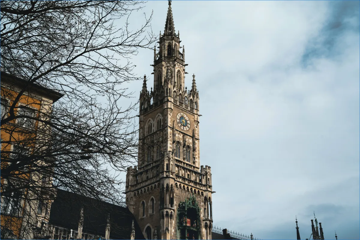 Gotischer Turm mit Uhr und wolkigem Himmel