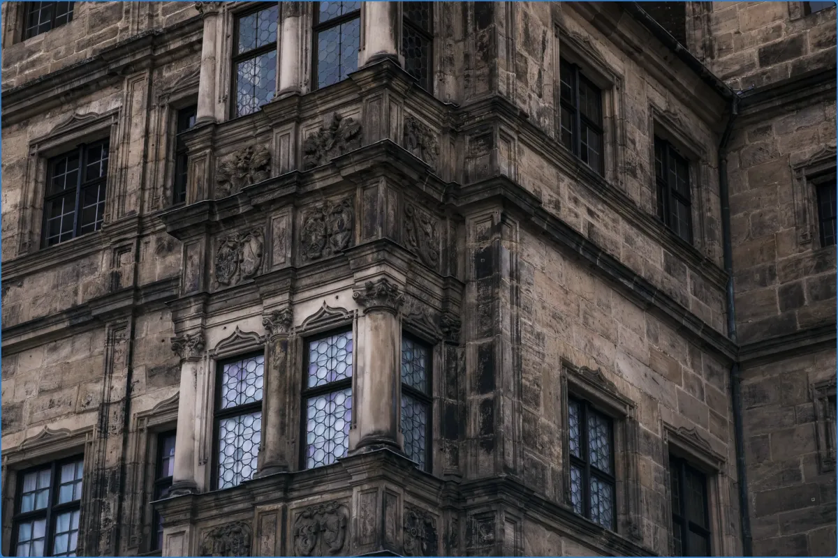 Detail eines alten Gebäudes mit verzierten Fenstern.