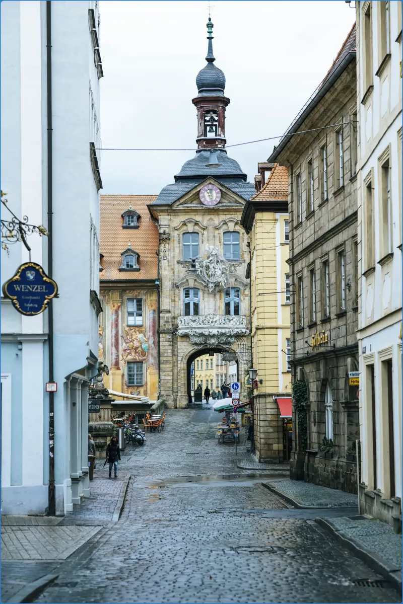 Historisches Gebäude mit Turm und Torbogen in einer Stadt.