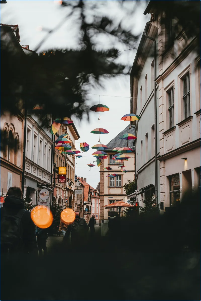 Straße mit schwebenden bunten Regenschirmen