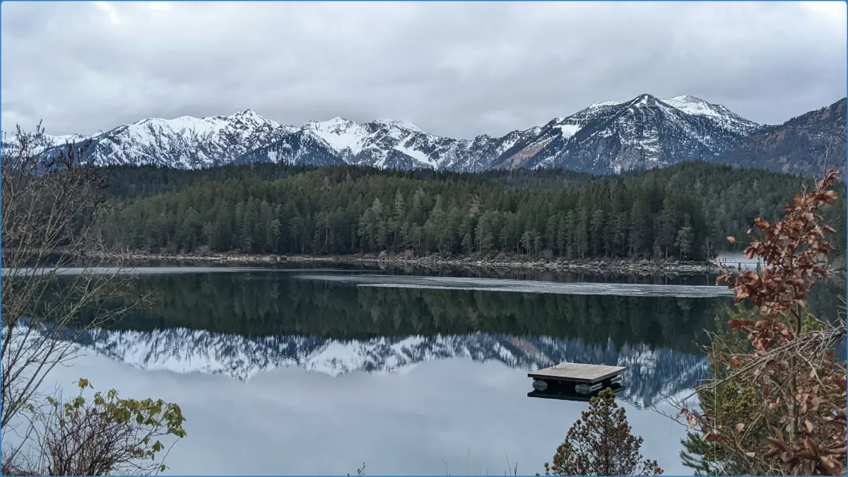 Bergsee mit schneebedeckten Bergen im Hintergrund.