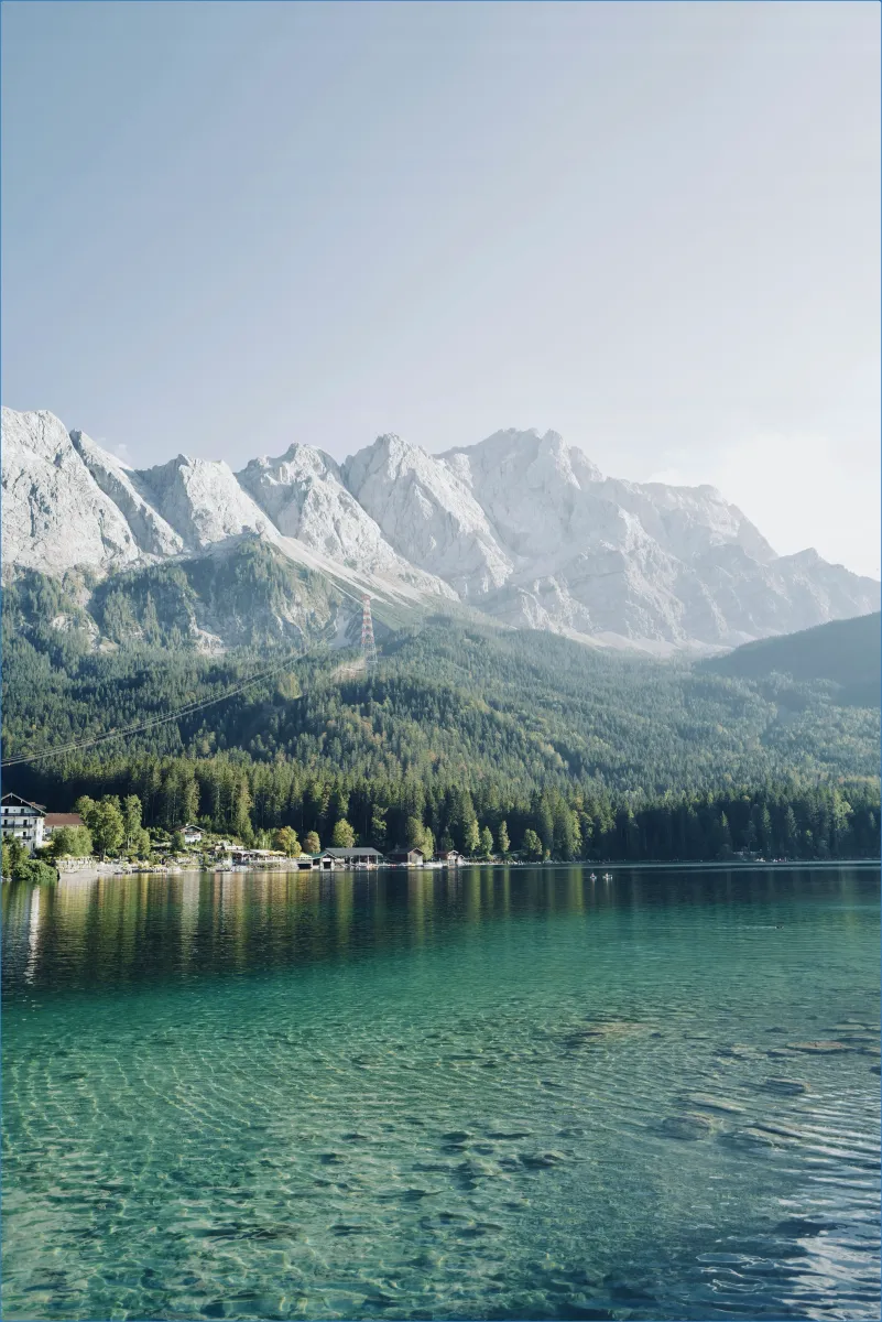 Berglandschaft mit klarem See im Vordergrund.