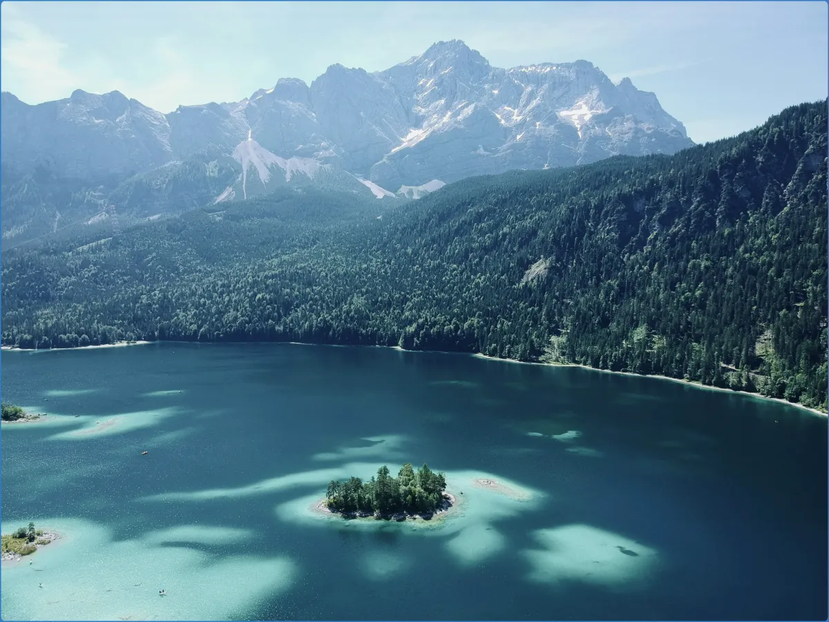 Bergsee mit Insel und Bergen im Hintergrund