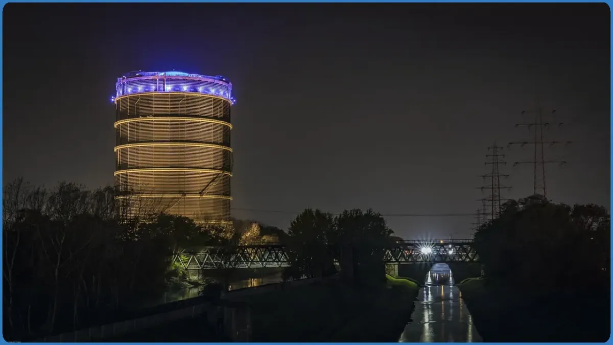 Beleuchteter Gasometer bei Nacht