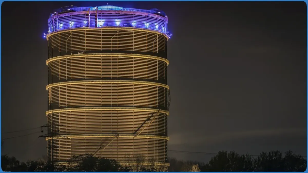 Beleuchteter Gasometer bei Nacht