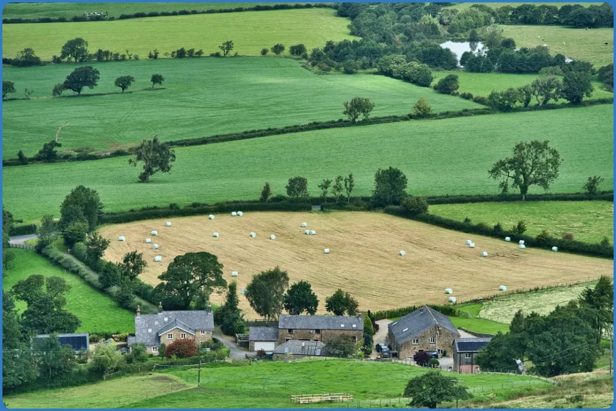 Landschaft mit Bauernhof und Feldern
