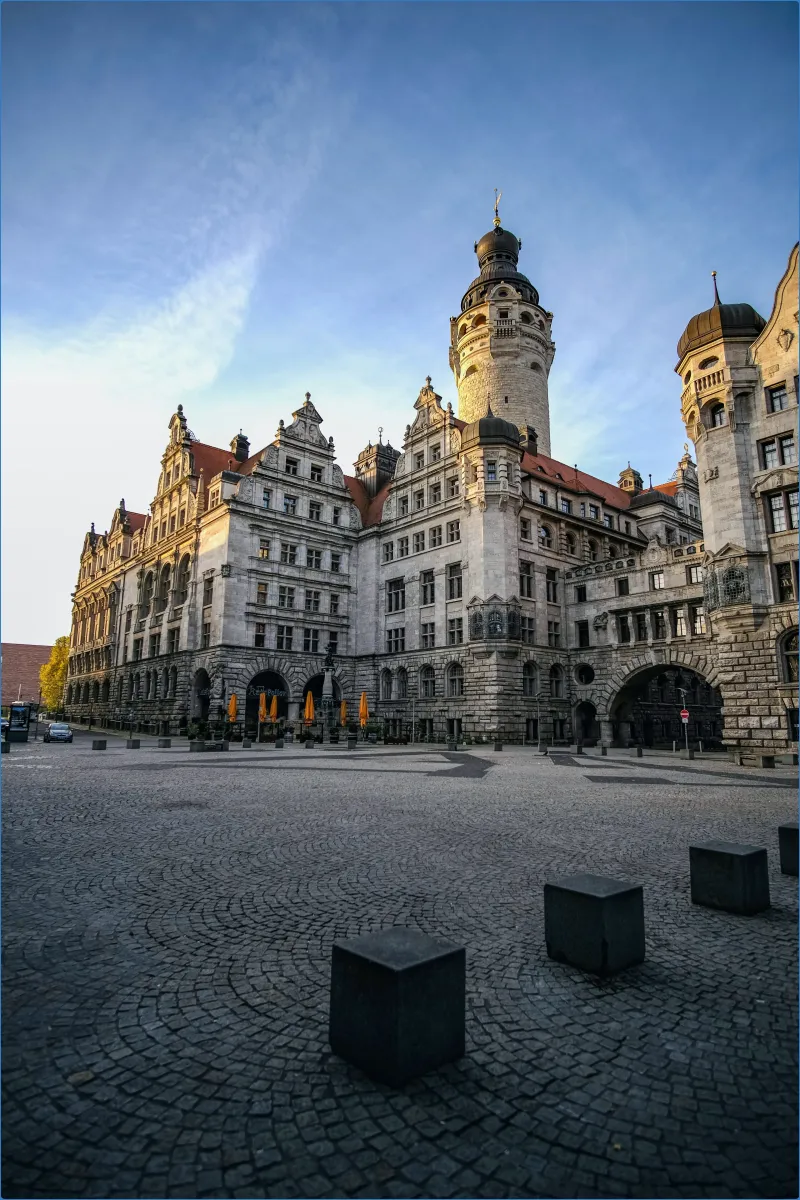 Historisches Gebäude mit Turm und gepflastertem Platz
