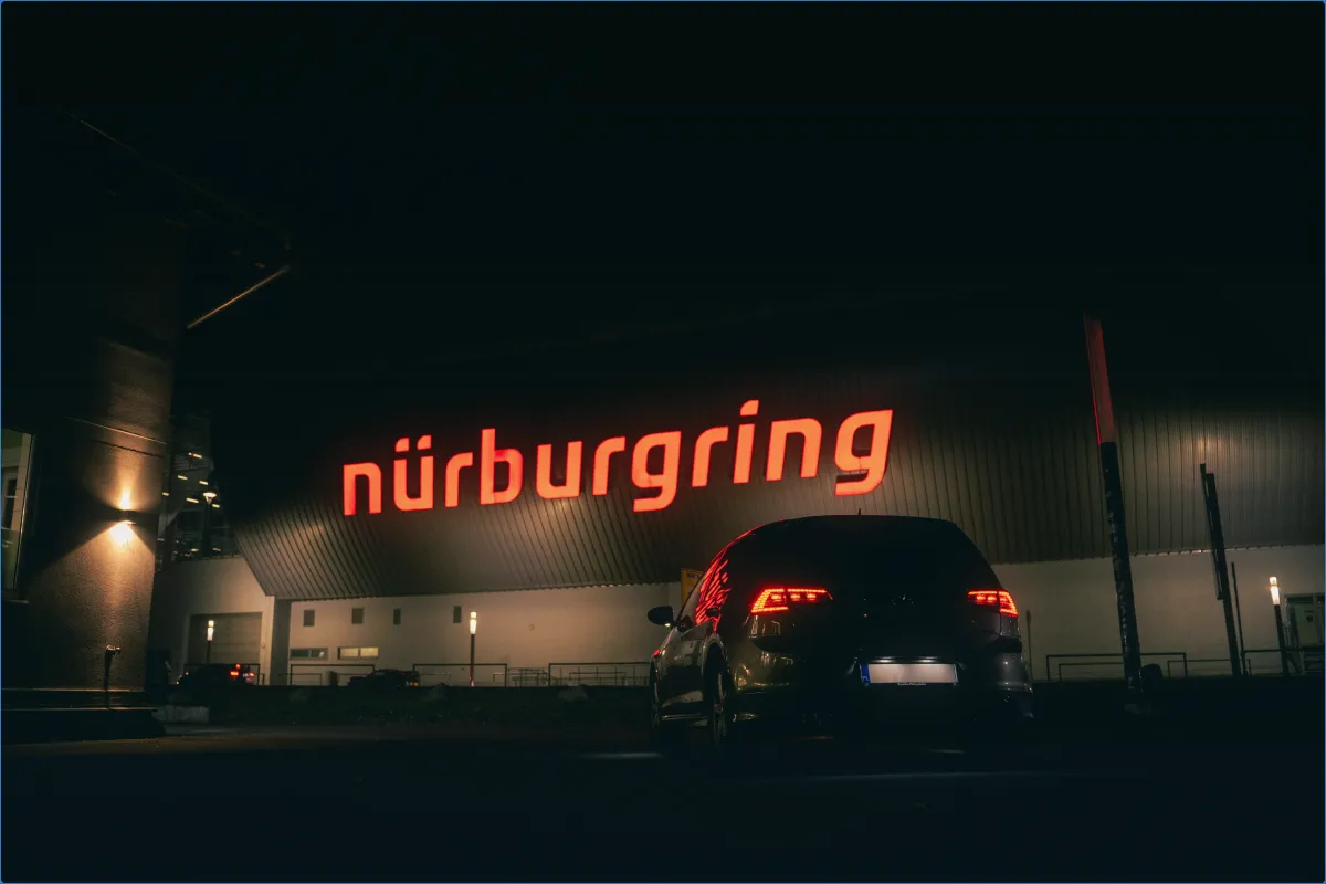 Auto vor Nürburgring-Schild bei Nacht