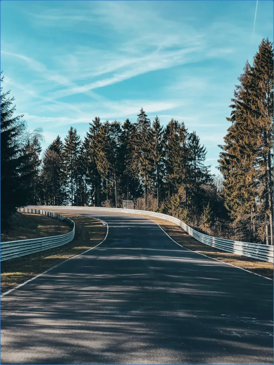 Rennstrecke mit Kurve und Bäumen im Hintergrund