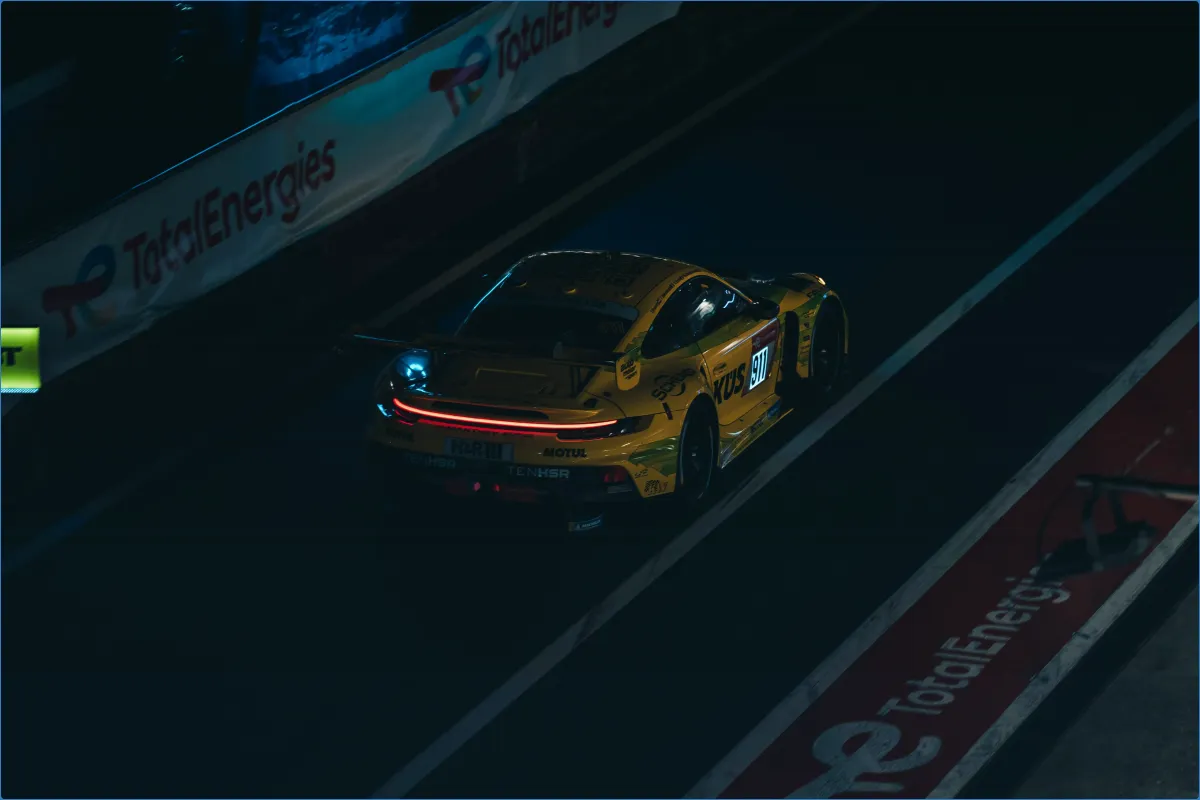 Gelbes Rennauto in der Boxengasse bei Nacht