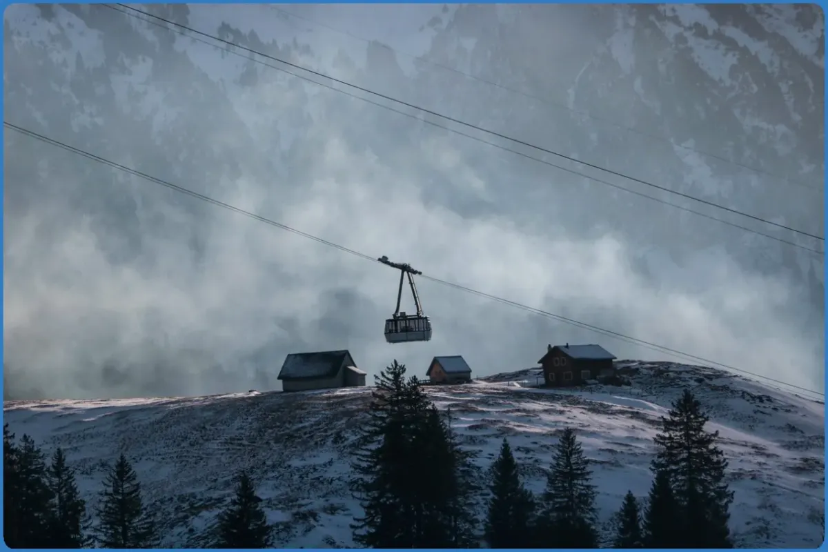 Seilbahn über verschneite Hütten in den Bergen.