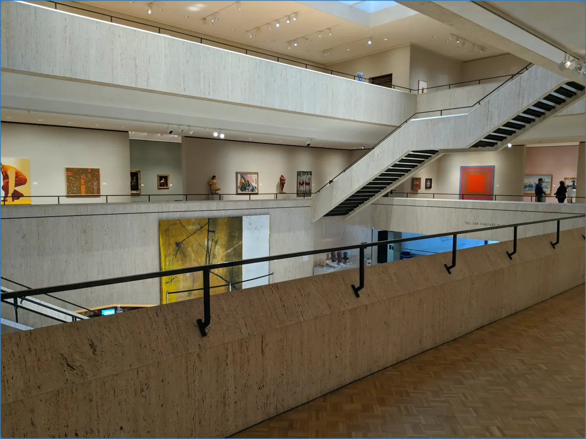 Innenansicht eines Kunstmuseums mit Gemälden und Skulpturen.