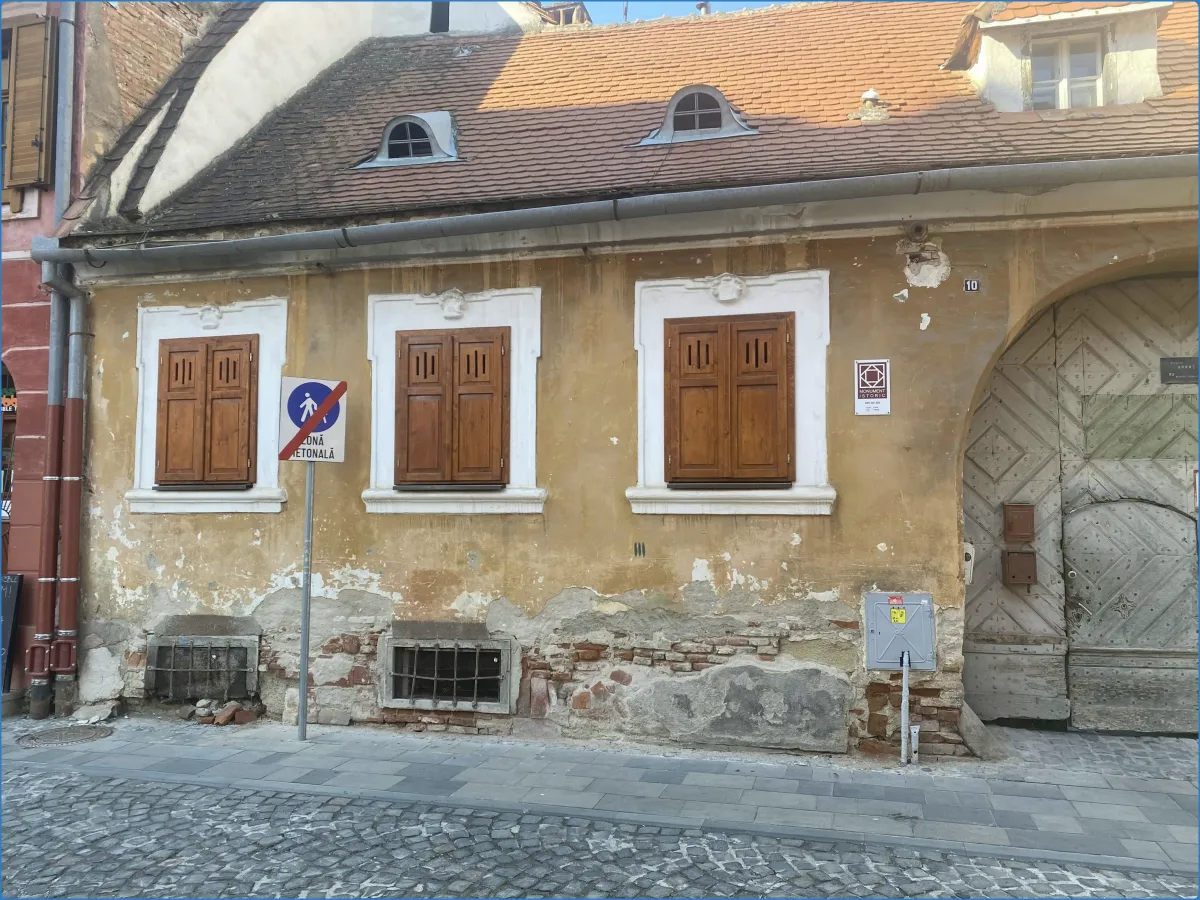 Altes Gebäude mit Holzfensterläden und Verkehrsschild