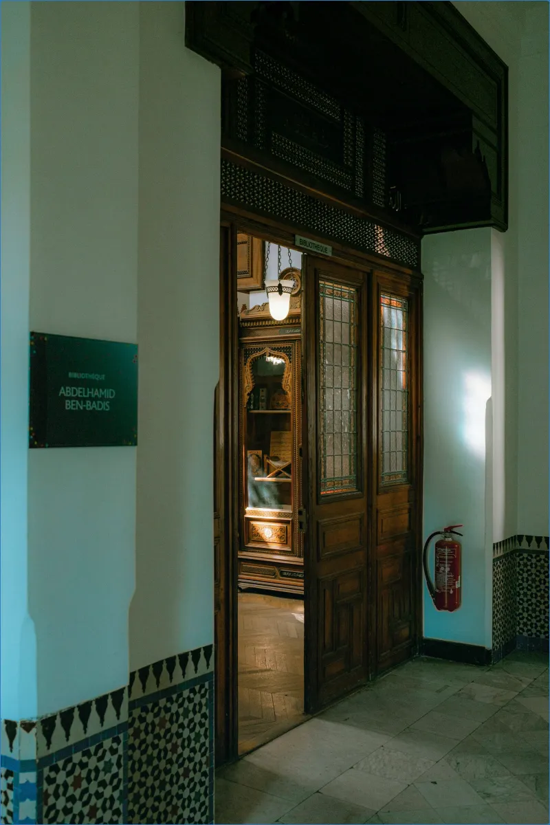 Geöffnete Tür zu einer Bibliothek mit Holztüren.