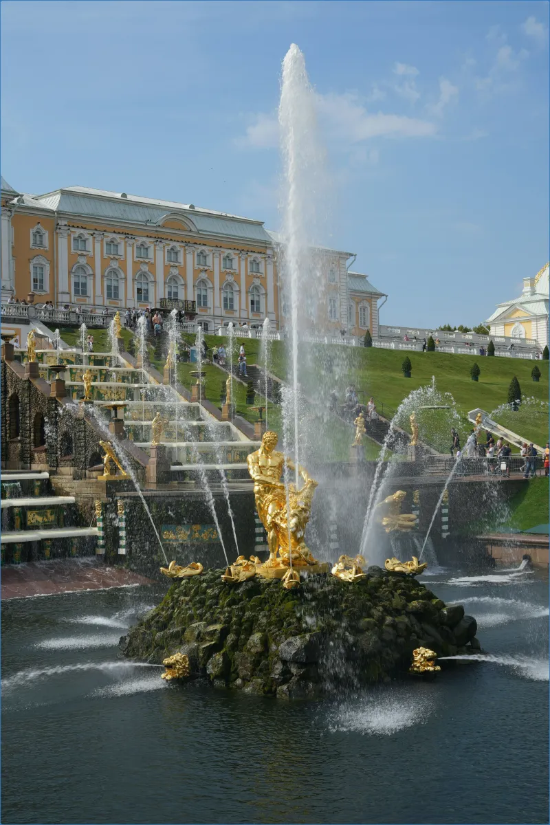 Goldene Statue und Springbrunnen vor einem Palast
