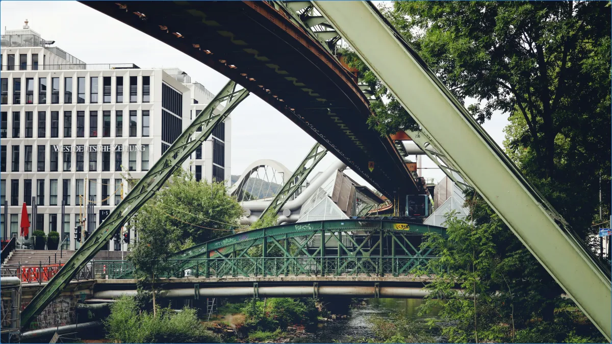 Schwebebahn in Wuppertal über Fluss und Brücke.
