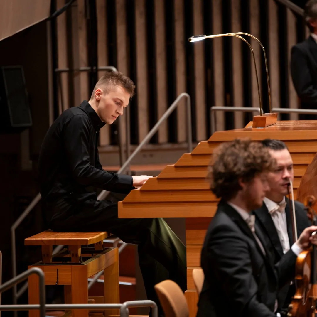 Mann spielt Orgel in einem Konzertsaal