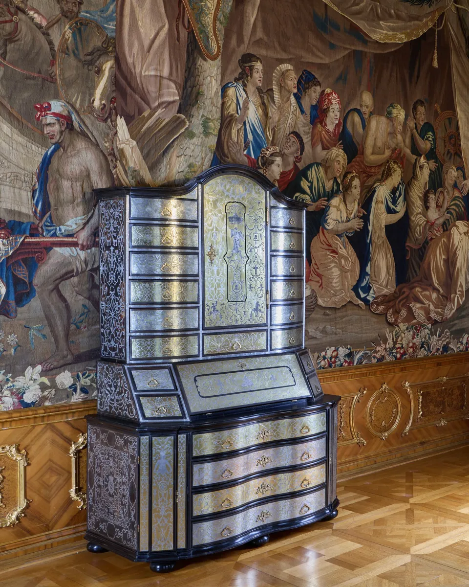 Antiker Schrank vor Wandteppich