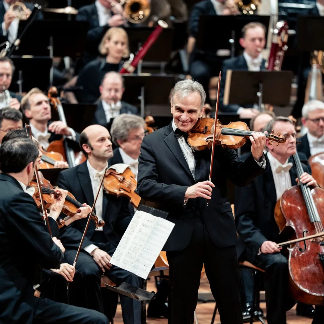 Dirigent mit Orchester auf der Bühne