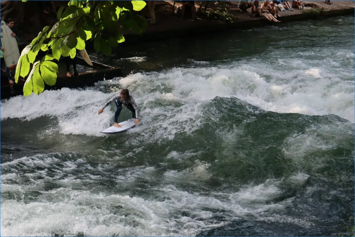 Person surft auf einer Flusswelle