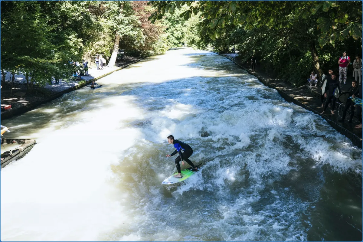 Person surft auf Flusswelle im Park.