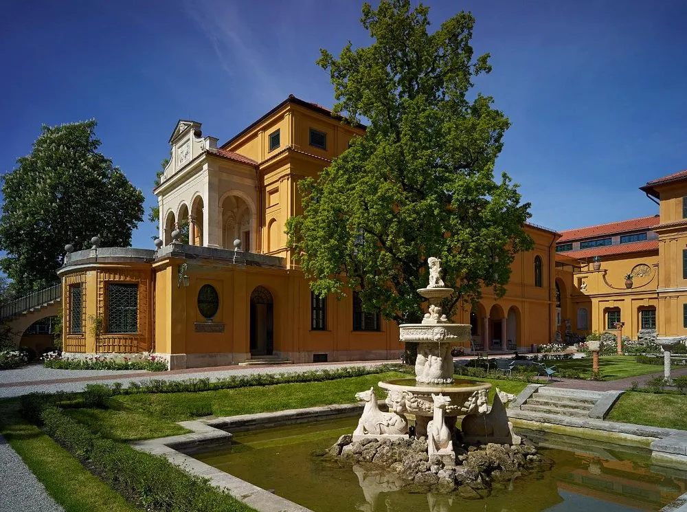 Historisches Gebäude mit Brunnen im Vordergrund
