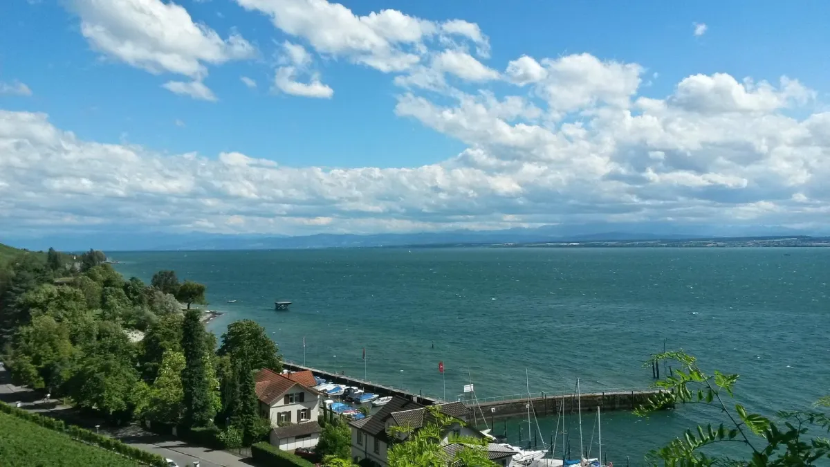 Blick auf einen See mit Booten und Häusern am Ufer.