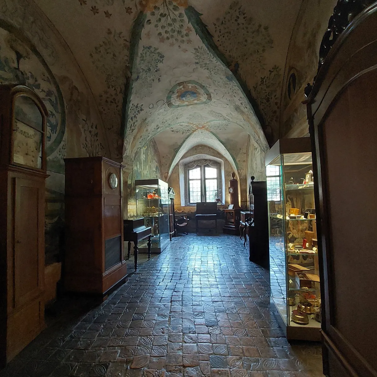 Historischer Raum mit bemalter Decke und antiken Möbeln.
