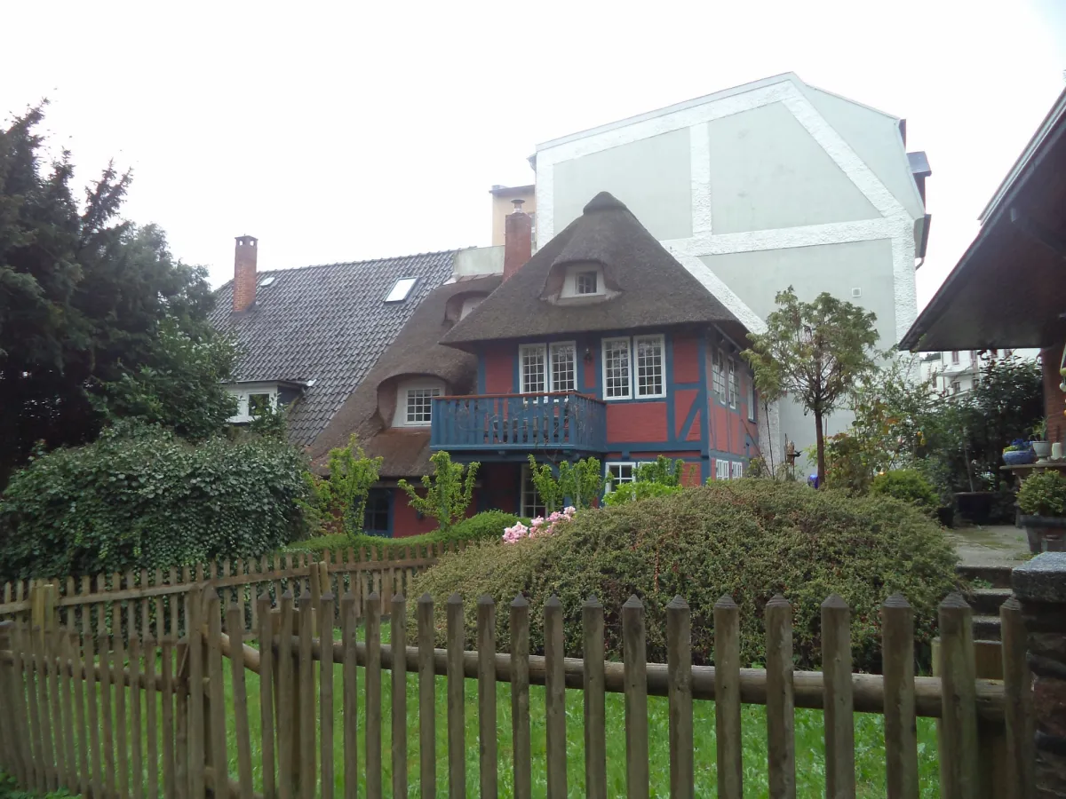 Fachwerkhaus mit Reetdach und Gartenzaun