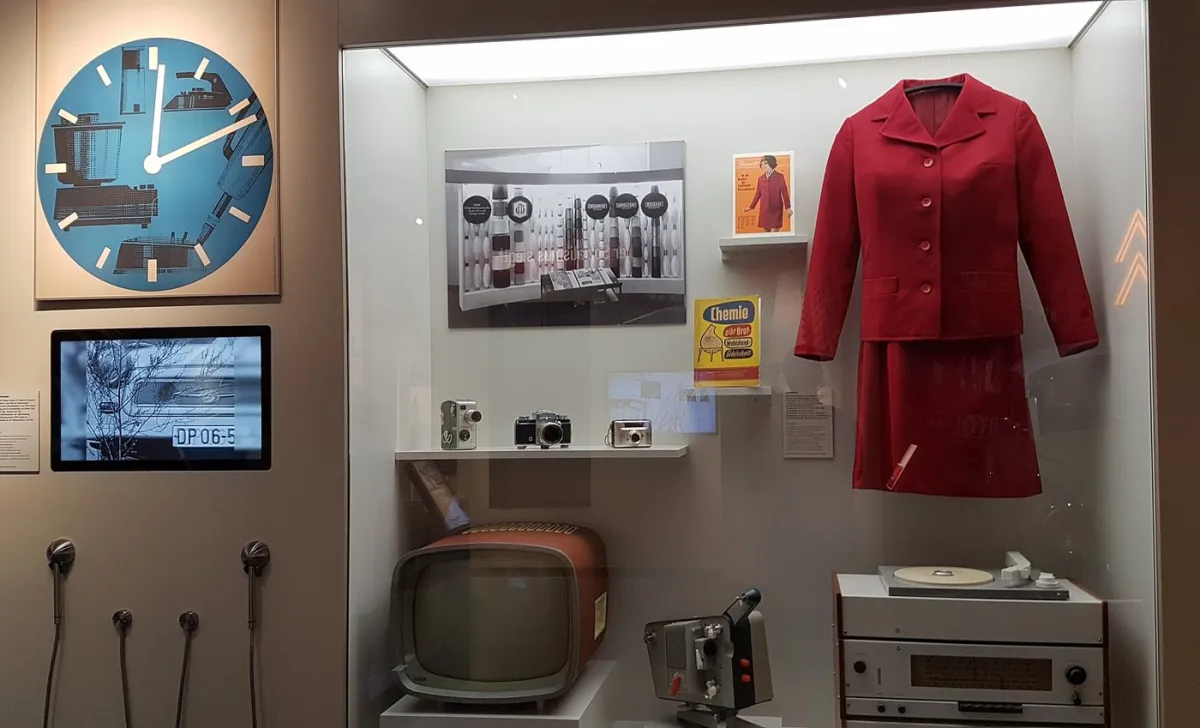 Vitrine mit Retro-Technologie und rotem Anzug
