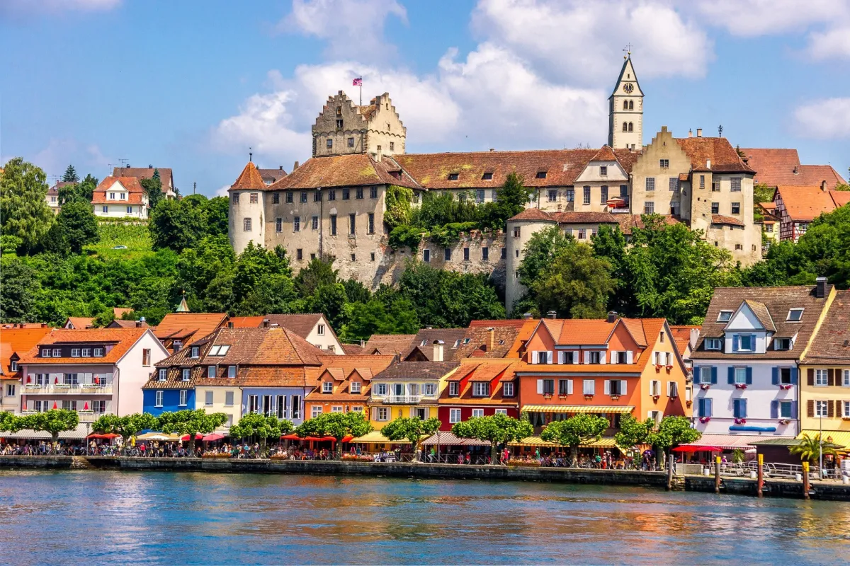 Mittelalterliche Burg und bunte Häuser am Flussufer