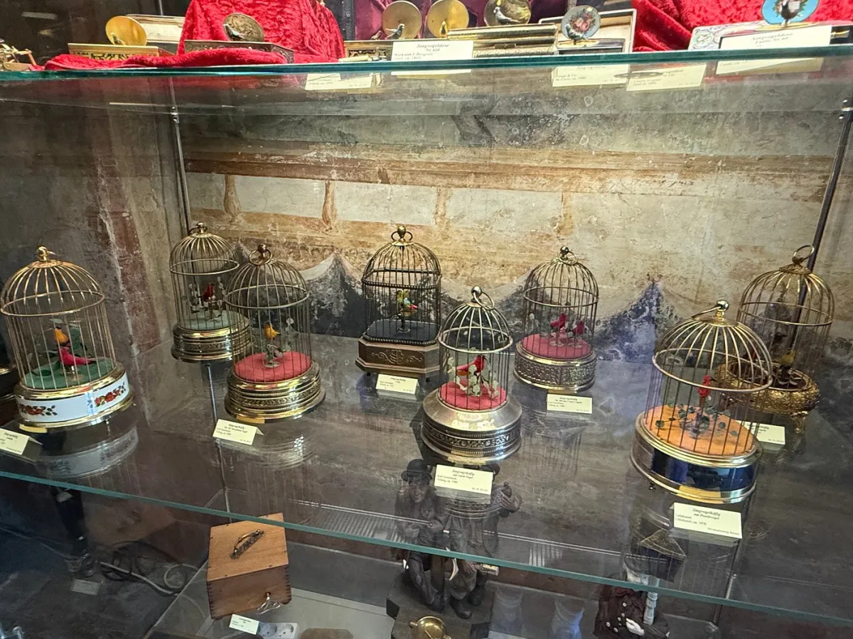 Vitrine mit dekorativen Vogelkäfigen