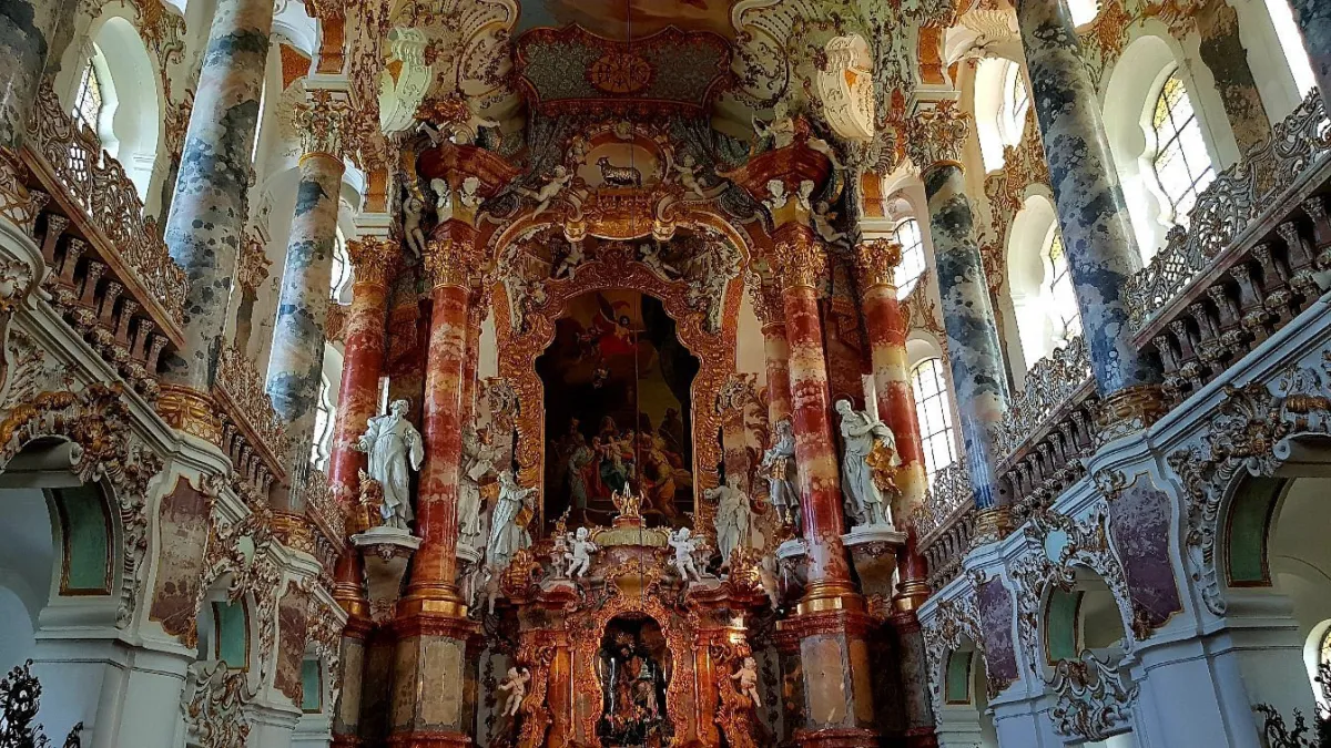Barocke Kircheninnenraum mit reich verzierten Säulen.