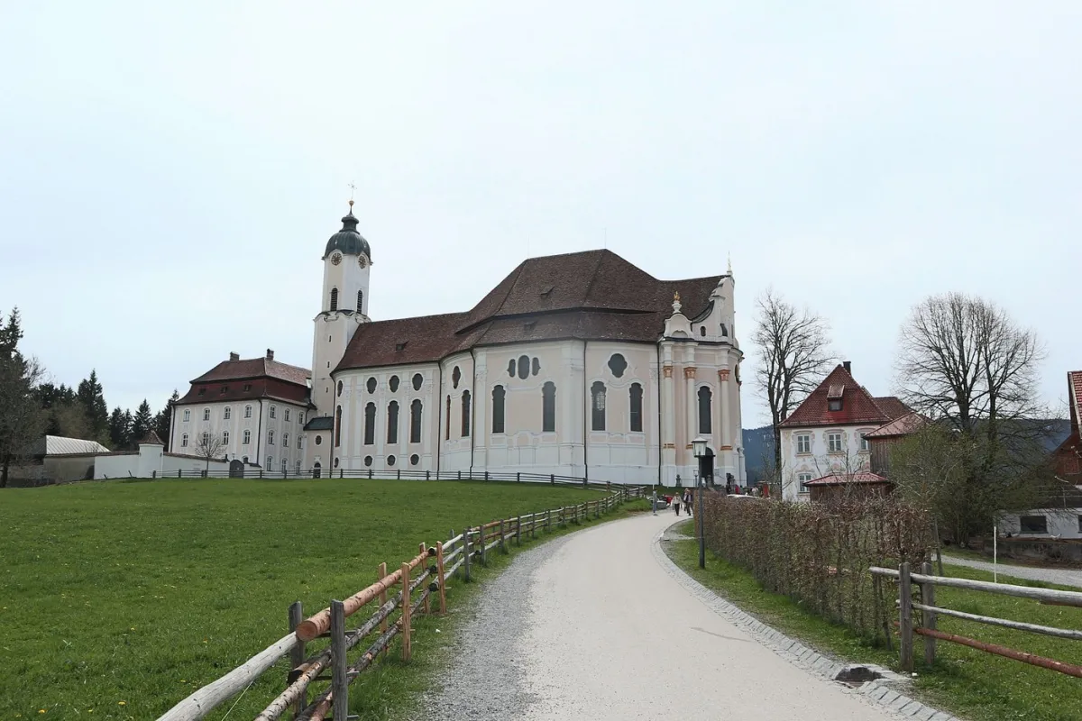 Barockkirche auf einem Hügel mit Weg und Zaun