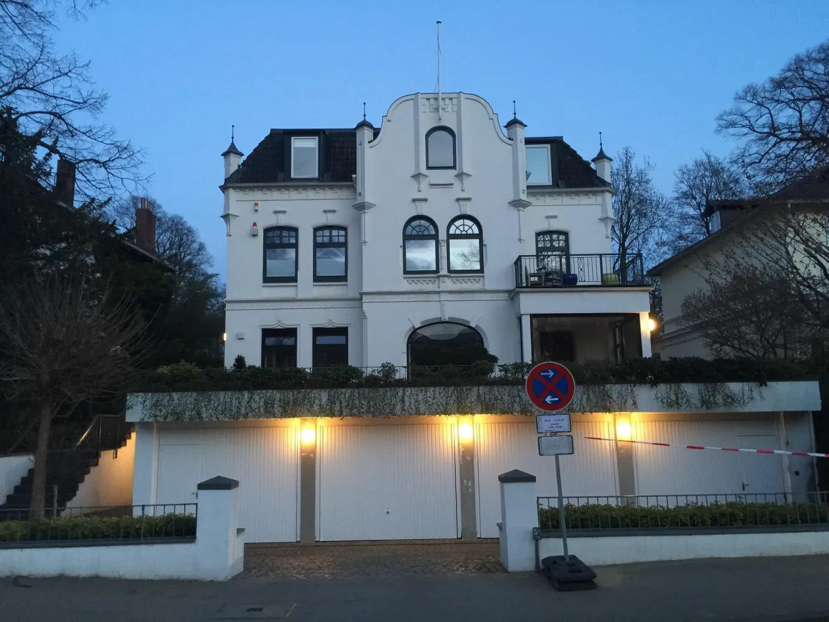 Weißes Haus mit Balkon und Garagen im Vordergrund
