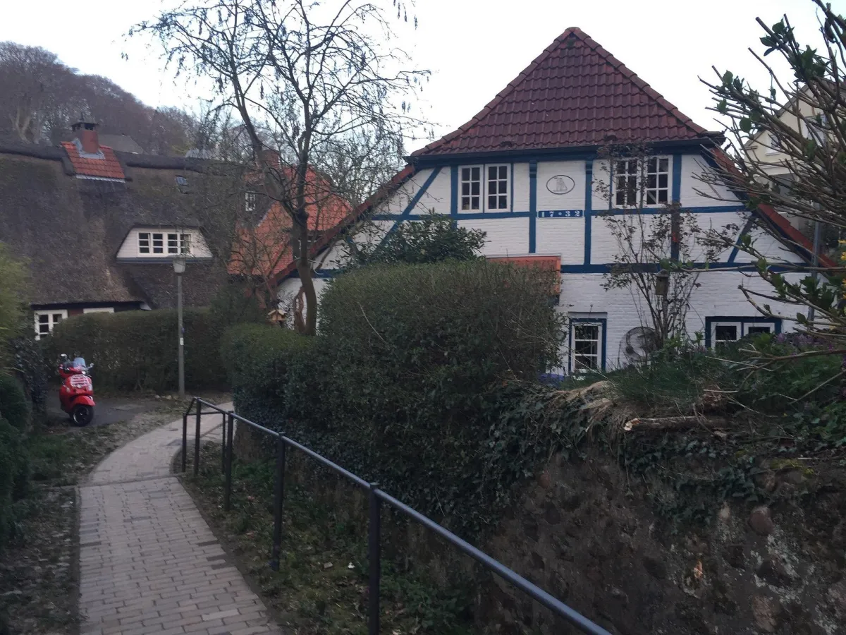 Fachwerkhaus mit rotem Dach und Vespa.