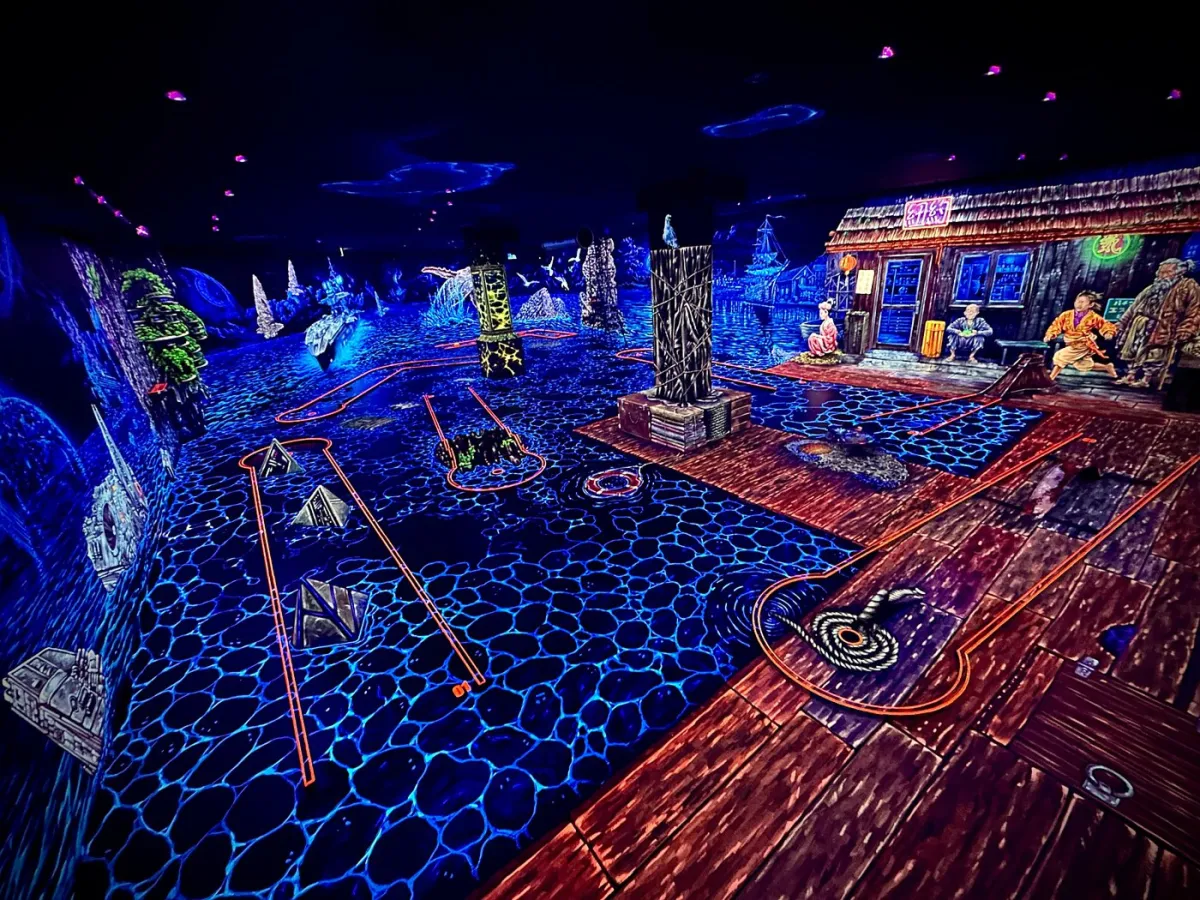Leuchtendes Minigolf mit neonfarbenen Hindernissen