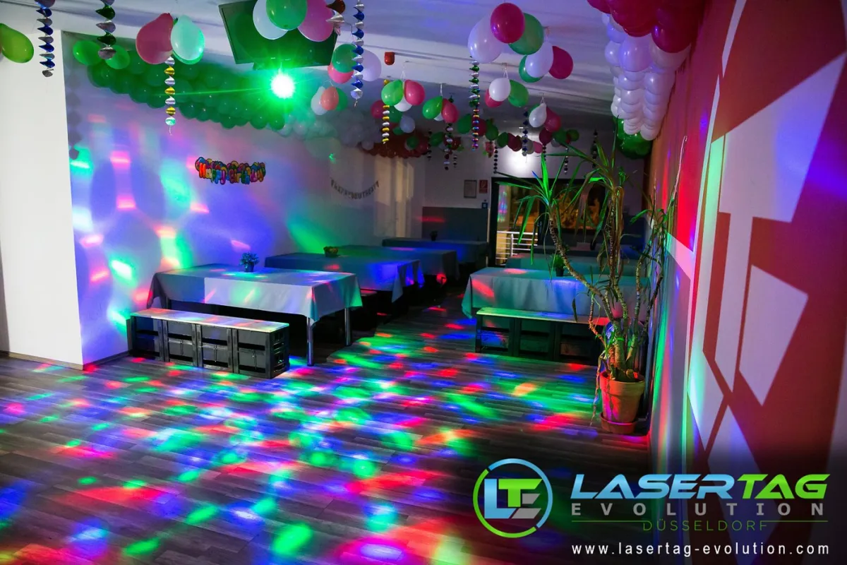 Dekorierter Partyraum mit bunten Lichtern und Ballons.