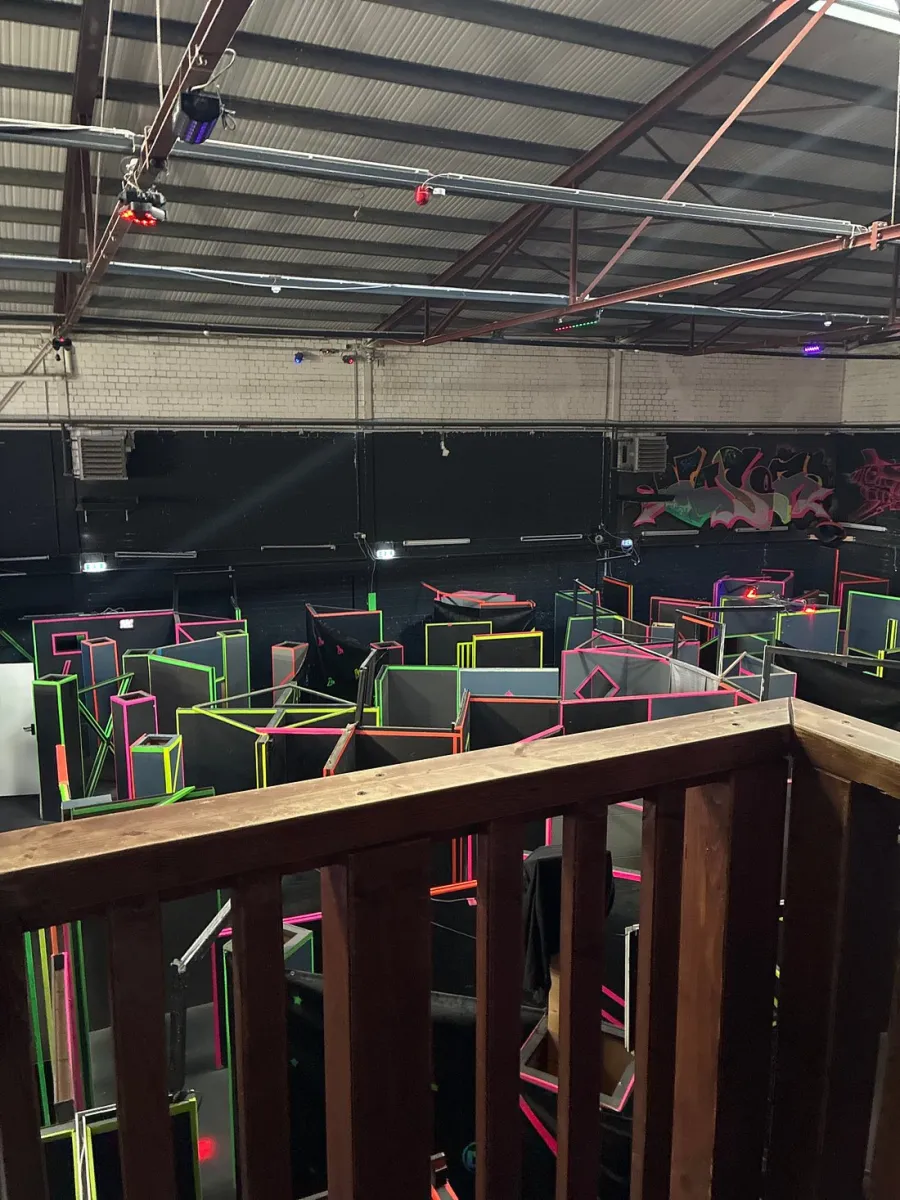 Innenansicht eines Lasertag-Areals mit Neonlichtern.