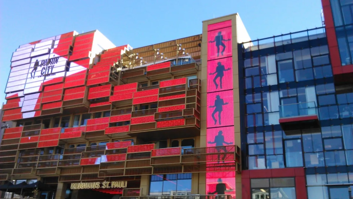 Gebäude mit roten LED-Panels und Tänzer-Silhouetten.